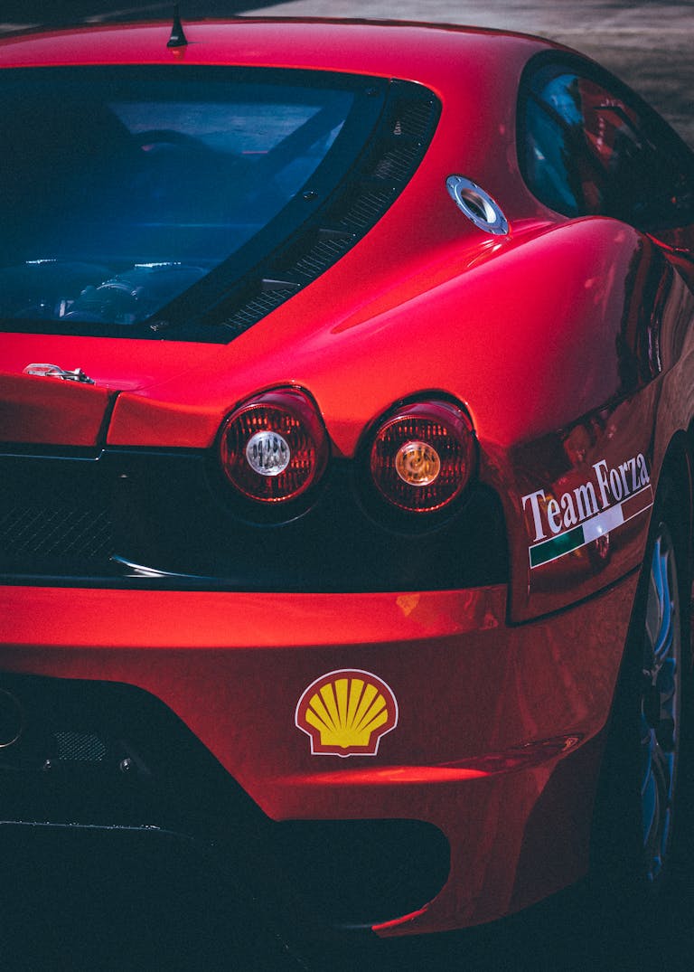 Detailed view of a red sports car featuring decals and taillights in a vertical shot.